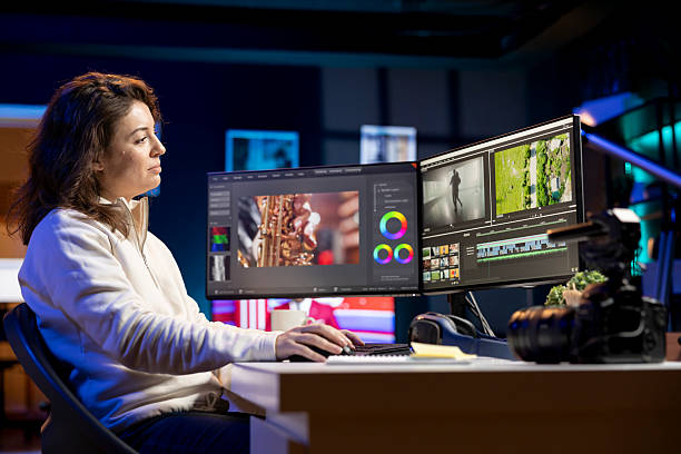 istock Smiling video editor working for production company checking stills on camera 2215395988