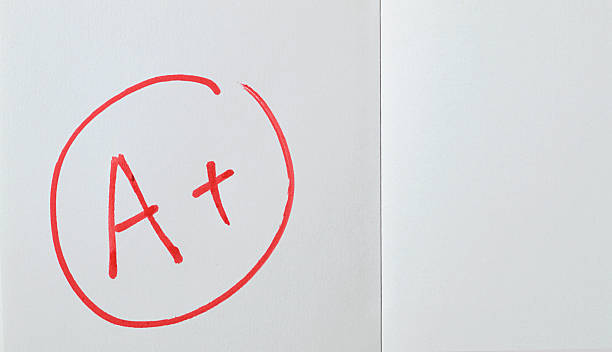 istock Perfect excellent grades - Encircled A+ or A plus hand written text in red sketch pen or felt tip pen, on paper from open notepad or full frame part of plain diary page 2215397510