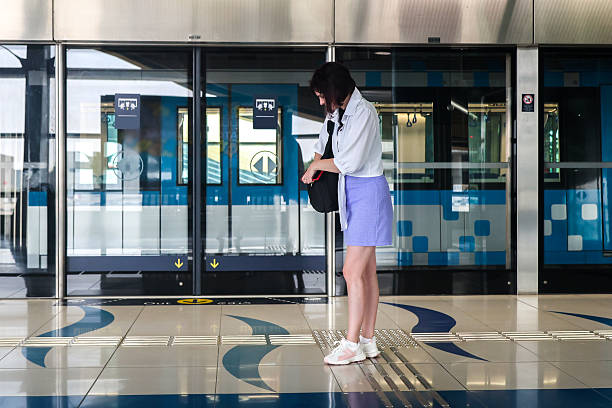 istock Confident Woman Standing on a Subway Platform, Waiting for Her Train in a Bustling City 2215399241