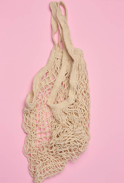 istock Empty reusable cotton mesh bag on pink background, top view 2215400971