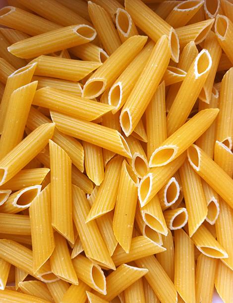 istock Uncooked pasta background, penne pasta view 2215401440