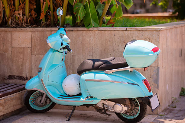 istock A blue scooter is parked near the city wall. 2215401575