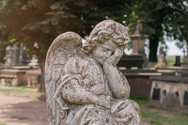 istock Little angel crying. Old stone statue. (concept children's mortality) 2215403332
