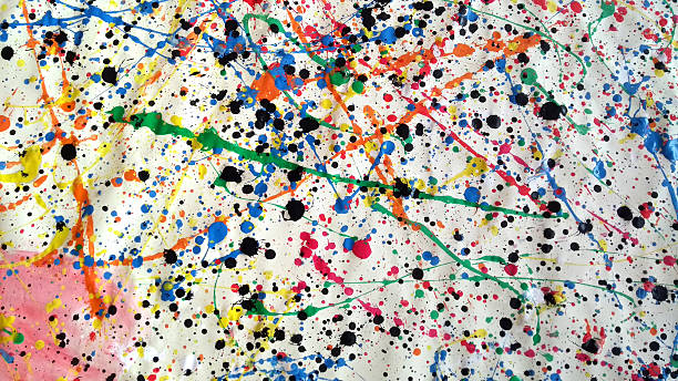 Large abstract splatter painting with multicolored paint drips and black ink spots on crumpled white canvas