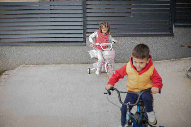 Little children ride bicycles.