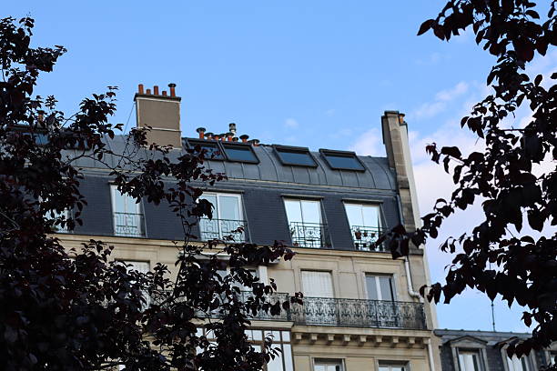 istock Elegant Parisian rooftop with modern skylights and traditional architecture against a clear blue sky 2215409272