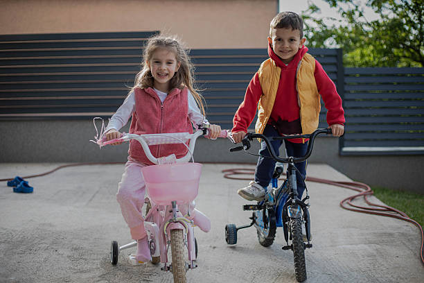 Little children ride bicycles.