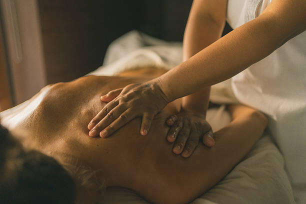 istock Young woman enjoys massage treatment 2215410733
