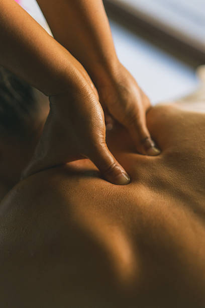 Young woman enjoys massage treatment at luxury resort, Maldives