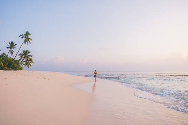 istock Young woman enjoys tropical beach at sunset 2215411156