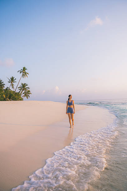 istock Young woman enjoys tropical beach at sunset 2215411201