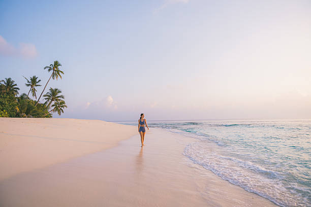 istock Young woman enjoys tropical beach at sunset 2215411211