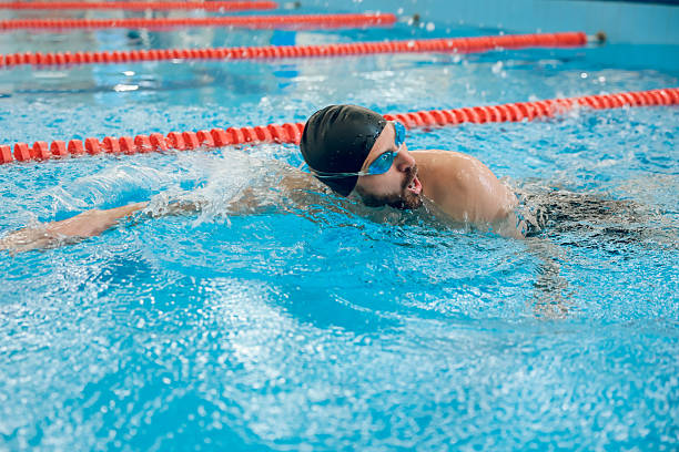 istock Man in black swimming cap swimming crawl style in the pool 2215412082