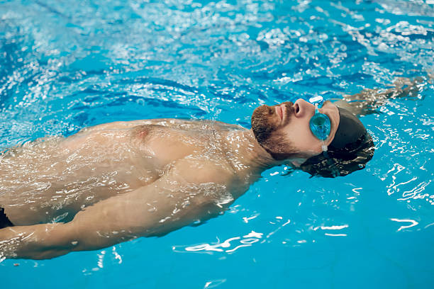 istock Man in swimming glasses and swimming cap spending time in a pool 2215412183