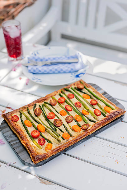 Vegetarian savoury frangipane tart. Topped with vibrant tomatoes and asparagus.