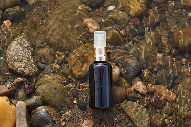 istock Black spray bottle on wet river stones 2215414277