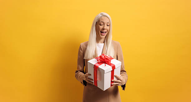 istock Surprised young woman looking at a present box 2215414504