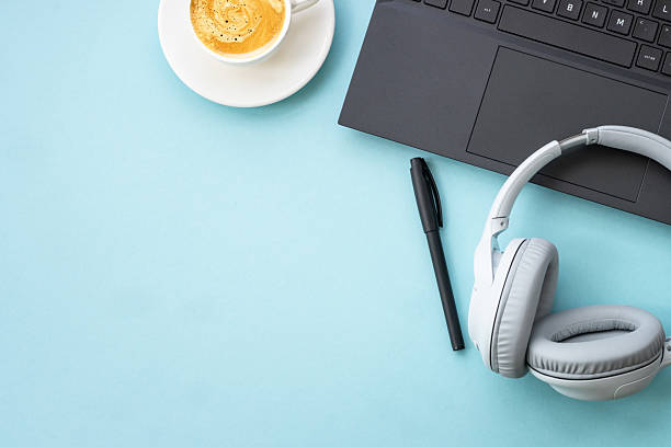 istock Office table desk with laptop, headphones, notepad and pen. 2215414787