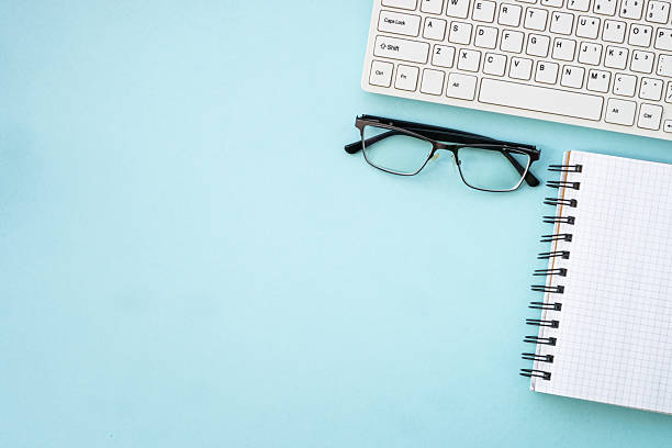 istock Office desk flat lay background with laptop, notepad and glasses. 2215414812