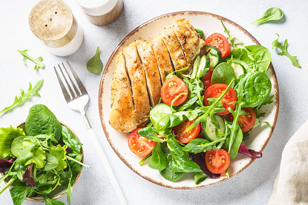 istock Green salad with chicken fillet on white. 2215414855
