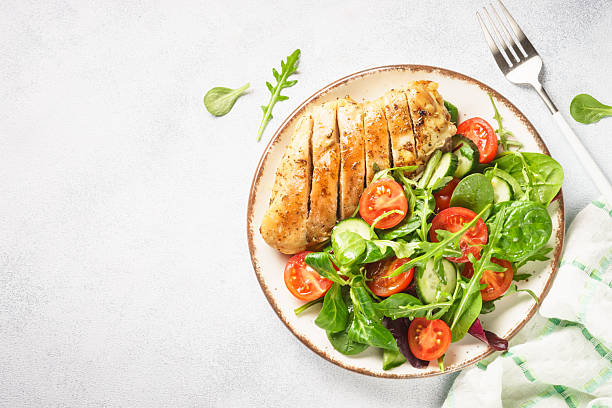 istock Green salad with chicken fillet on white. 2215414866