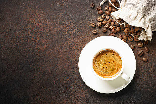 istock Cup of coffee, roasted coffee beans and filter holder at dark table. 2215415168