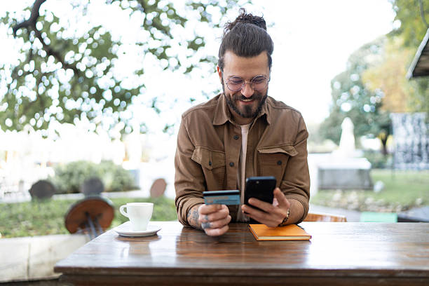 istock Young man making online payment using credit card and smartphone 2215418423
