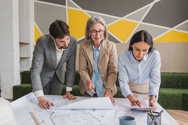 istock Mid section of diverse male and female architects engineer designer with tablet discussing over a plan at office. Business, engineering, technology and office concept 2215418729