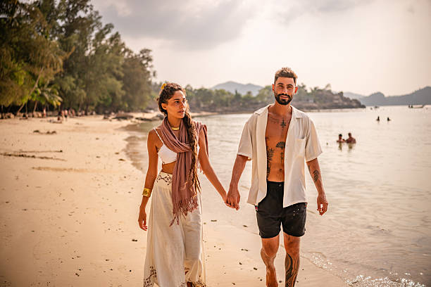 istock Couple enjoying a romantic walk on the beach in Thailand during sunset while exploring their love and connection 2215420111