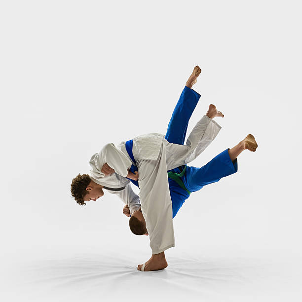istock Two young athletes in mid-air judo throw, one executing perfect hip movement while opponent flies with legs up, symbolizing combat competition. 2215421573