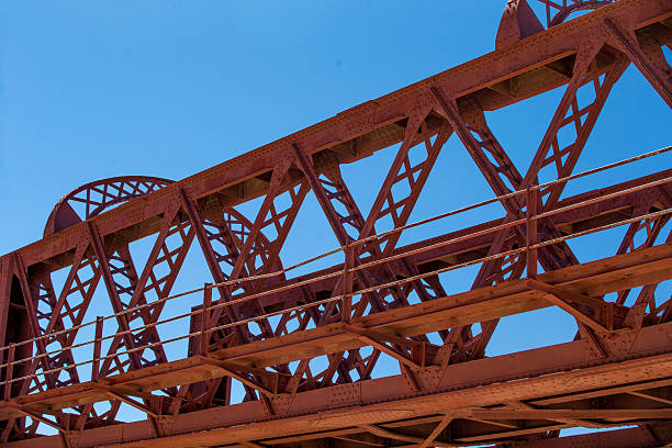 istock Red metal bridge construction against clear blue sky 2215421682