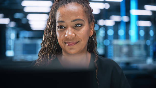 istock Portrait of Multiracial Female IT Developer Working on Desktop in Data Center. System Administrator Works on Web Services, Cloud Computing, Server Analytics, Cyber Security Maintenance Concept 2215422135