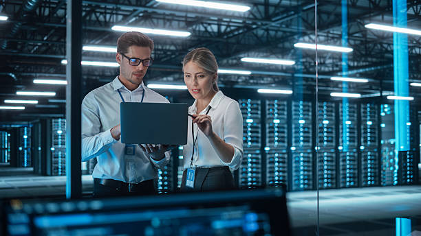 istock In Technology Research Facility: Female Project Manager Talks With Chief Engineer, they Consults with Each Other. Team of Industrial Engineers, Developers Work on Engine Design Using Computer 2215422583