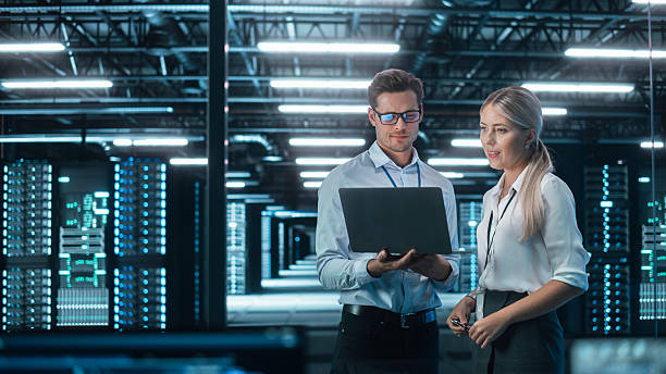 istock Male CEO Discusses Problem Solving with Female Partner in Office, They Brainstorming while Look on a Laptop. Smart Businesspeople Working in Finance. Specialists Work in Team Concept 2215422631