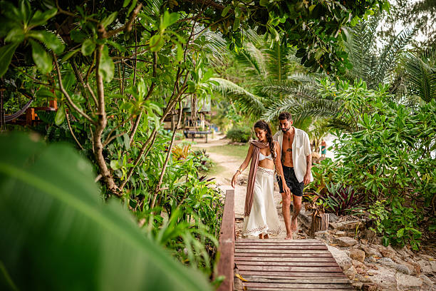 istock Young couple enjoying a romantic stroll along a tropical path in Thailand, surrounded by lush greenery and vibrant nature 2215422686