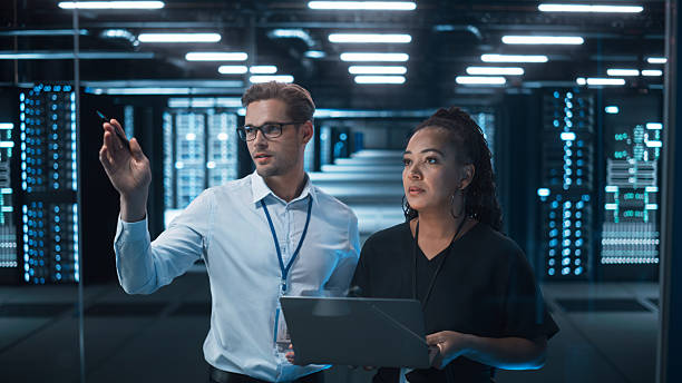 istock Factory Office Facility: Female Chief Engineer Holds Laptop Computer, Look Away and Brainstorming with Male Project Manager. Modern Industry Research and Development Center. 2215423041