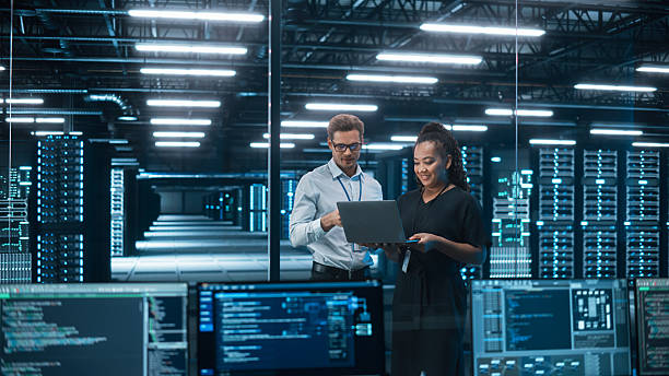 istock Diverse Big Data Center Server: e-Business Enrepreneur and IT Specialist talk, Use Laptop. Information Technology Engineer and System Administrator Monitoring Web Services Cloud Solution Software 2215423393