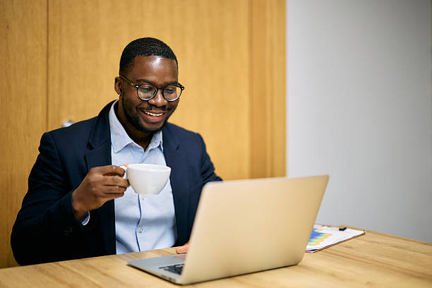 istock Young businessman drinking coffee and working on laptop in the office 2215425206