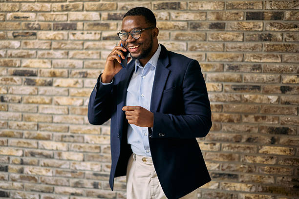 istock Young businessman smiling while talking on the phone in the office 2215425323
