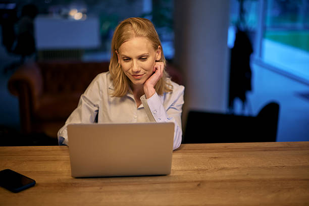 istock Businesswoman working late at night in office using laptop 2215425433