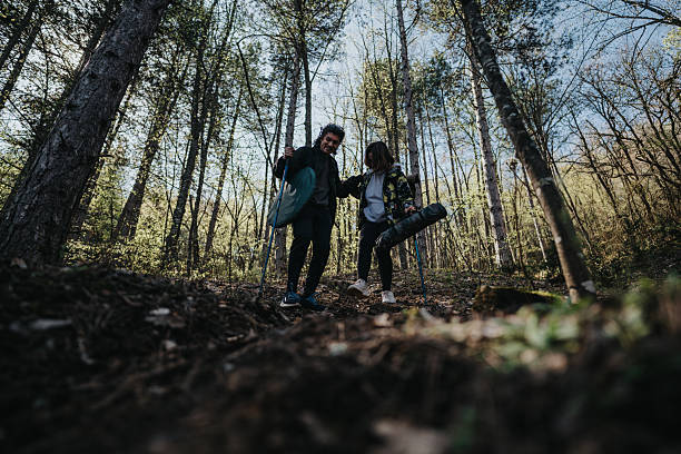 istock Two individuals enjoy a nature hike in a serene forest surrounded by tall trees. 2215426000