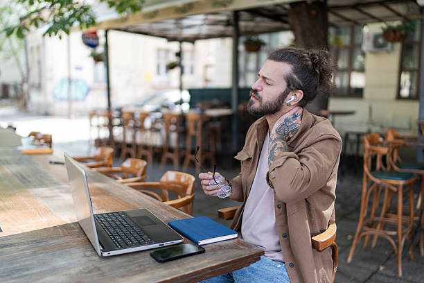 istock Freelancer suffering neck pain while working remotely at outdoor cafe 2215427734