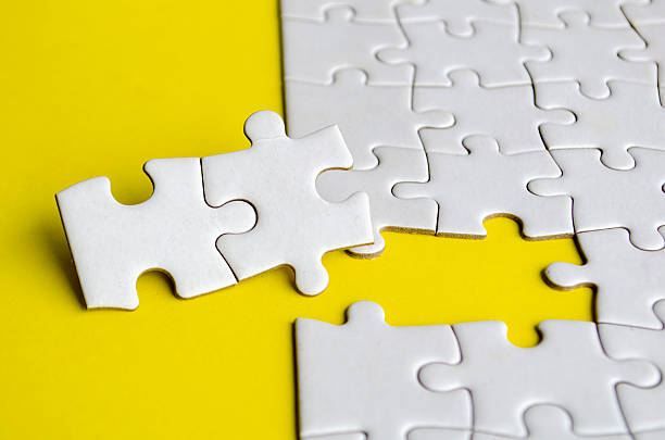 istock Close up of missing jigsaw puzzle pieces. Solution concept 2215430119
