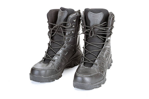 istock Black military combat boots with laces and rugged soles, front view on white background. Durable and sturdy footwear designed for outdoor activities and tactical use 2215430551