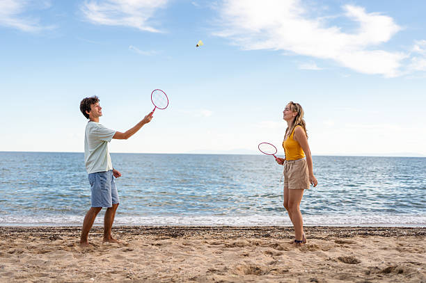 istock Young couple playing badminton on the beach 2215433250