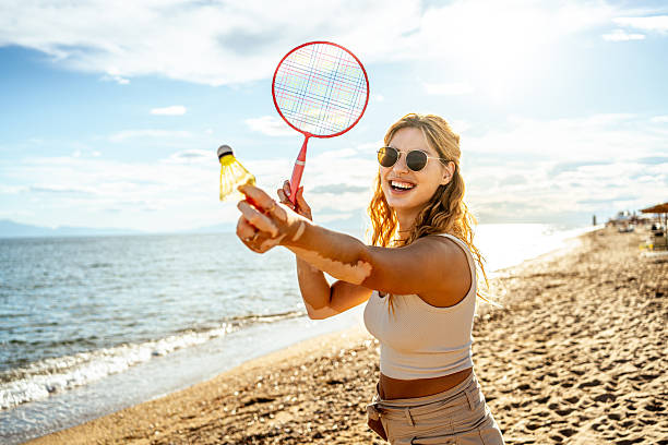 istock Young woman playing badminton on the beach 2215433357