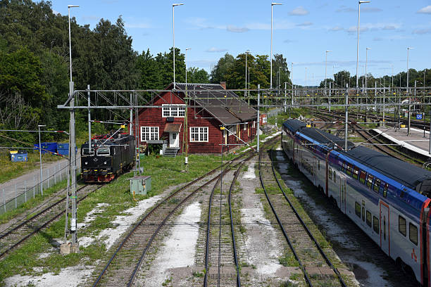 The Halssberg railway station with an approaching train and some railway tracks, captured during summer season.