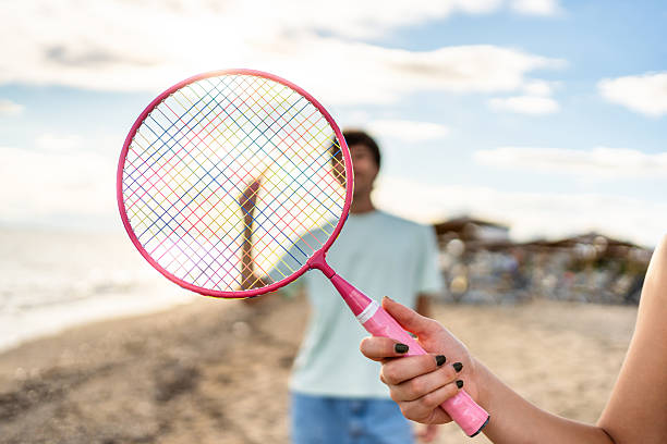 istock Woman holding a badminton racket on the beach 2215433891