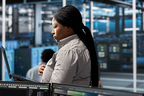 istock Employee using laptop to oversee data center machines 2215435265
