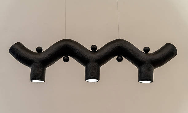 Modern sculptural black pendant lamp suspended in a minimalist interior